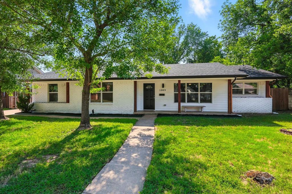 Ranch-style house with covered porch, brick siding, and roof with shingles