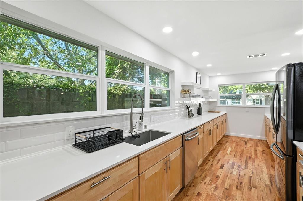 1009 Walnut Street Irving, TX 75060 - Photo 10 of 39 Kitchen with decorative backsplash, freestanding refrigerator, light wood-type flooring, light stone counters, and open shelves