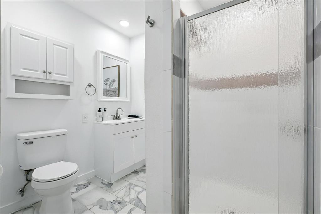 1009 Walnut Street Irving, TX 75060 - Photo 24 of 39 Full bathroom featuring light marble finish floors, a shower stall, and vanity