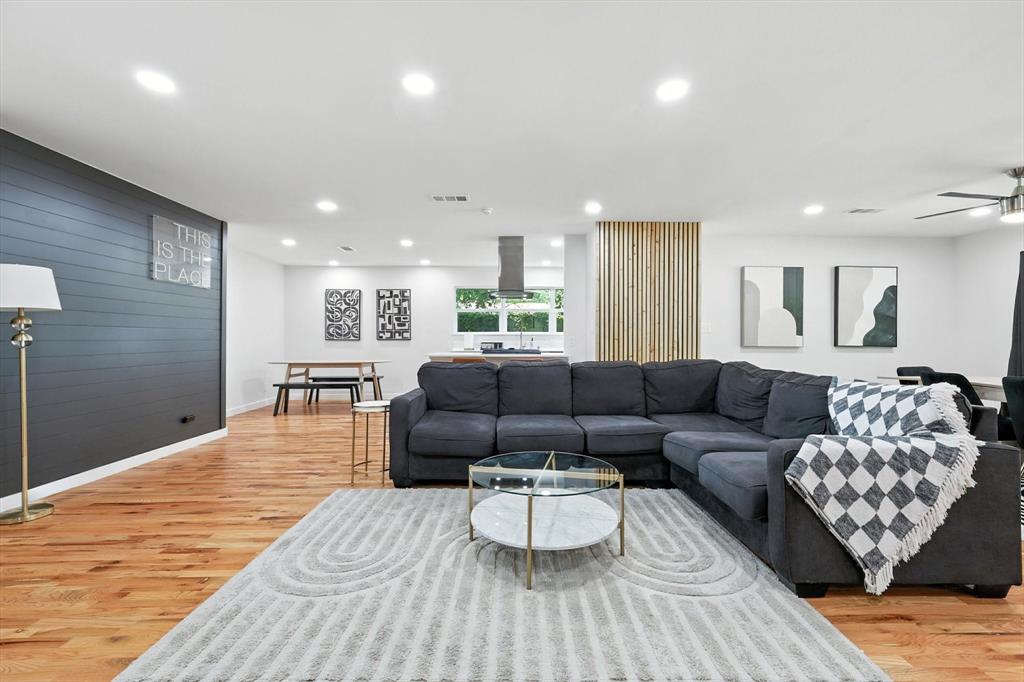 1009 Walnut Street Irving, TX 75060 - Photo 8 of 39 Living area with recessed lighting, light wood-style floors, ceiling fan, wooden walls, and an accent wall