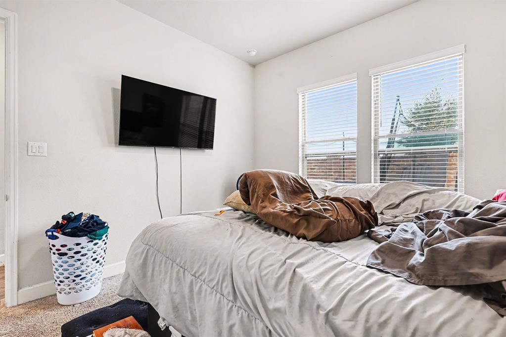 2208 Rothbury Drive Forney, TX 75126 - Photo 8 of 15 a bedroom with a bed and a flat screen tv