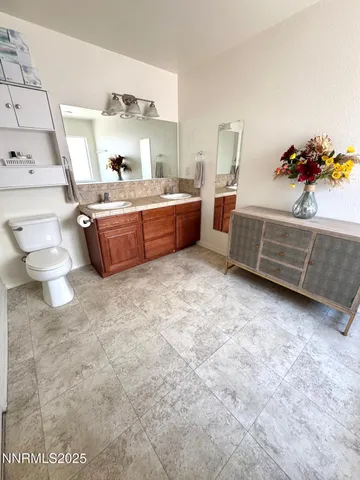 a bathroom with a double vanity sink mirror and toilet
