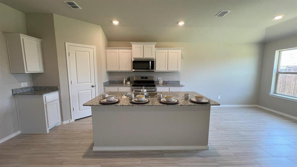 829 Round Robin Lane Rhome, TX 76078 - Photo 25 of 27 a view of kitchen with stainless steel appliances granite countertop a stove a sink and a refrigerator