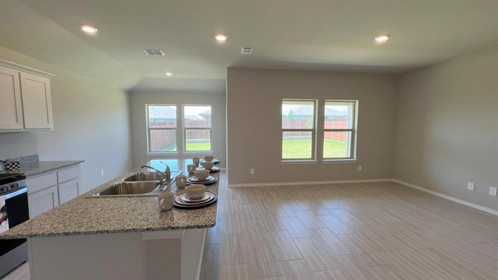 a kitchen with stainless steel appliances granite countertop wooden floors and granite counter tops