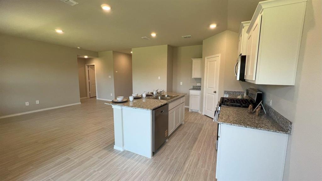 829 Round Robin Lane Rhome, TX 76078 - Photo 2 of 27 a large kitchen with stainless steel appliances granite countertop a lot of counter space and wooden floor