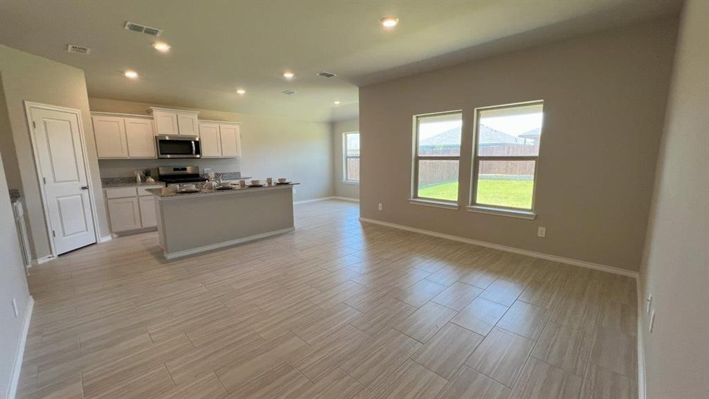 829 Round Robin Lane Rhome, TX 76078 - Photo 4 of 27 a kitchen with stainless steel appliances granite countertop a stove top oven a sink and a refrigerator