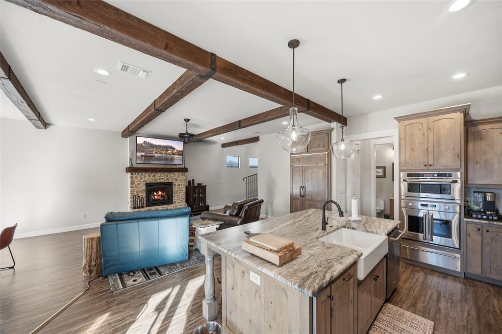 3105 Pastor Street Dallas, TX 75212 - Photo 2 of 28 CUSTOM BUILT HOME WITH Kitchen featuring pendant lighting, Luxury Vinyl wood like floors, light stone countertops, stainless steel double oven, and a lit fireplace