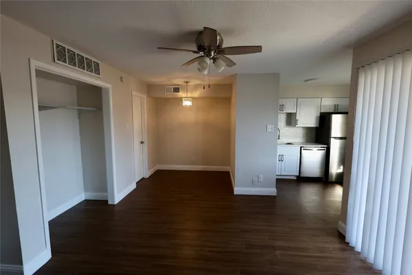 a view of a hallway with wooden floor and cabinet