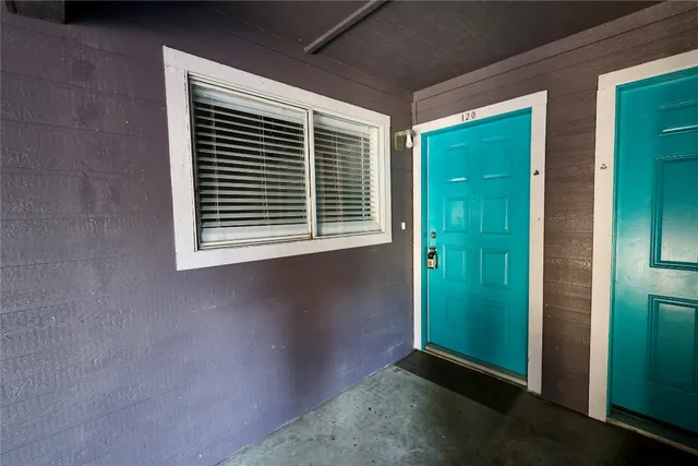 a view of an empty room with window and stairs
