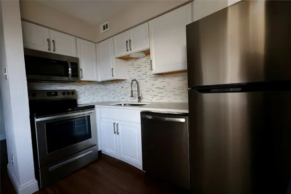 a kitchen with a refrigerator a sink and cabinets