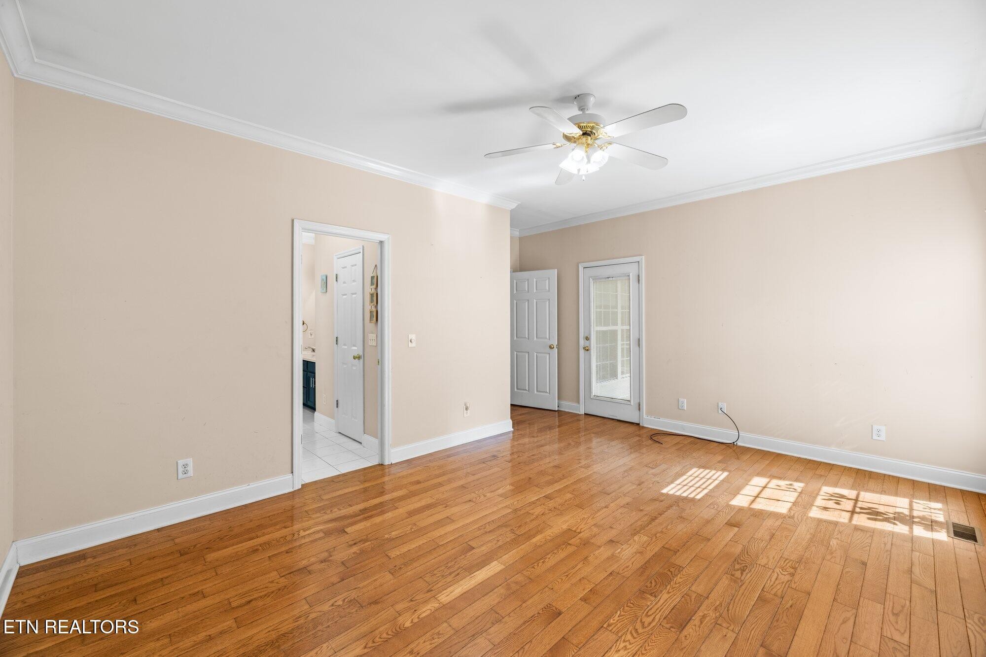 192 Savannah Ridge Trail Cleveland, TN 37323 - Photo 12 of 23 a view of an empty room with wooden floor and a ceiling fan