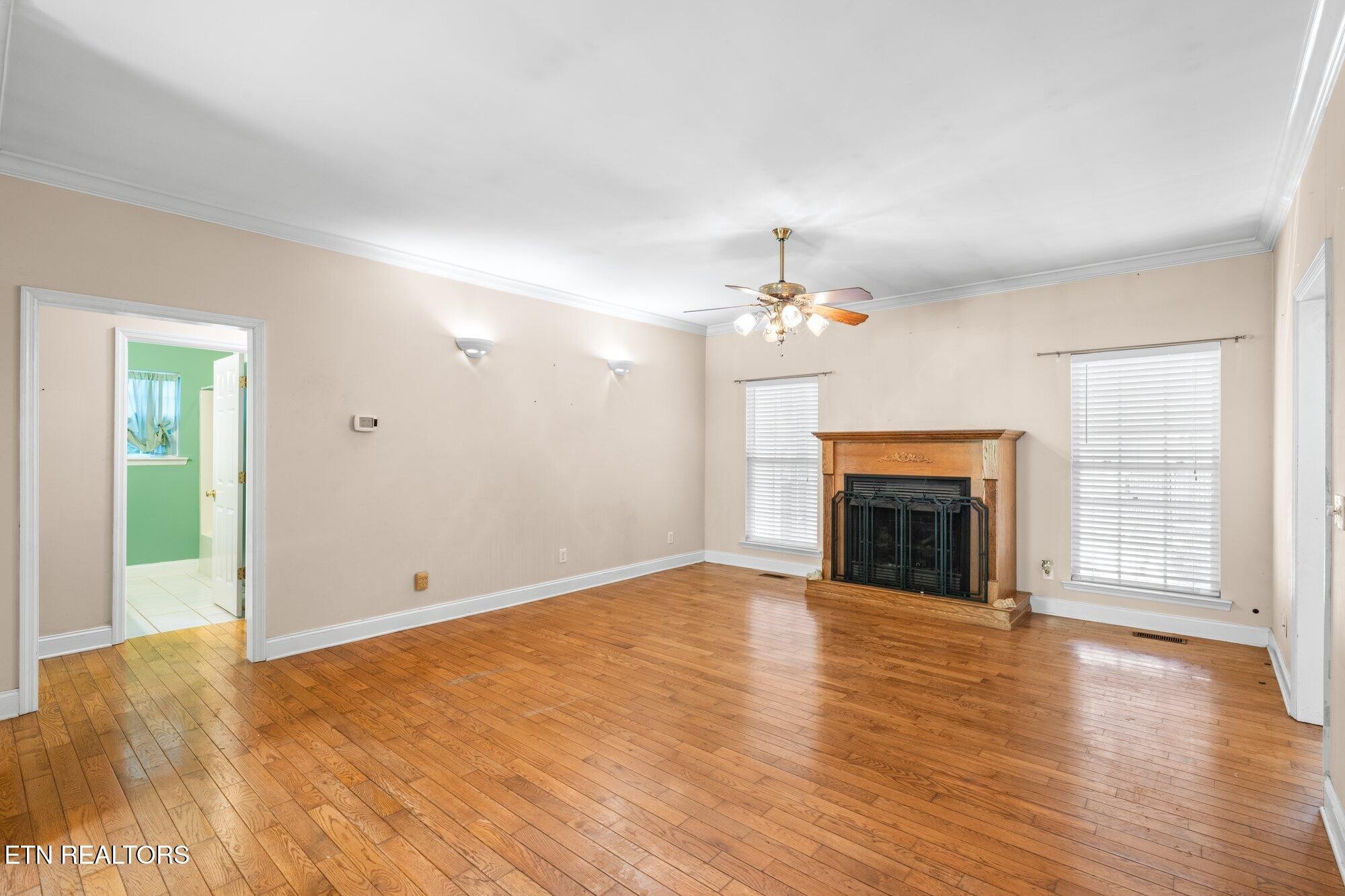 192 Savannah Ridge Trail Cleveland, TN 37323 - Photo 6 of 23 an empty room with wooden floor fireplace and chandelier