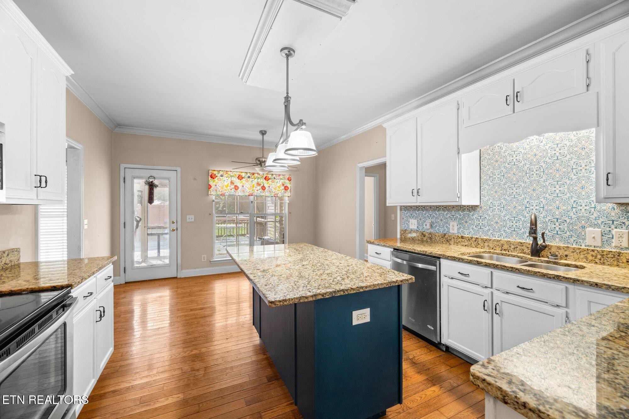 192 Savannah Ridge Trail Cleveland, TN 37323 - Photo 9 of 23 a kitchen with stainless steel appliances granite countertop wooden cabinets a sink dishwasher a stove and a dining table with wooden floor
