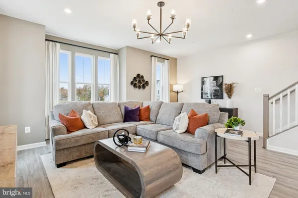 a living room with furniture ceiling fan and a window