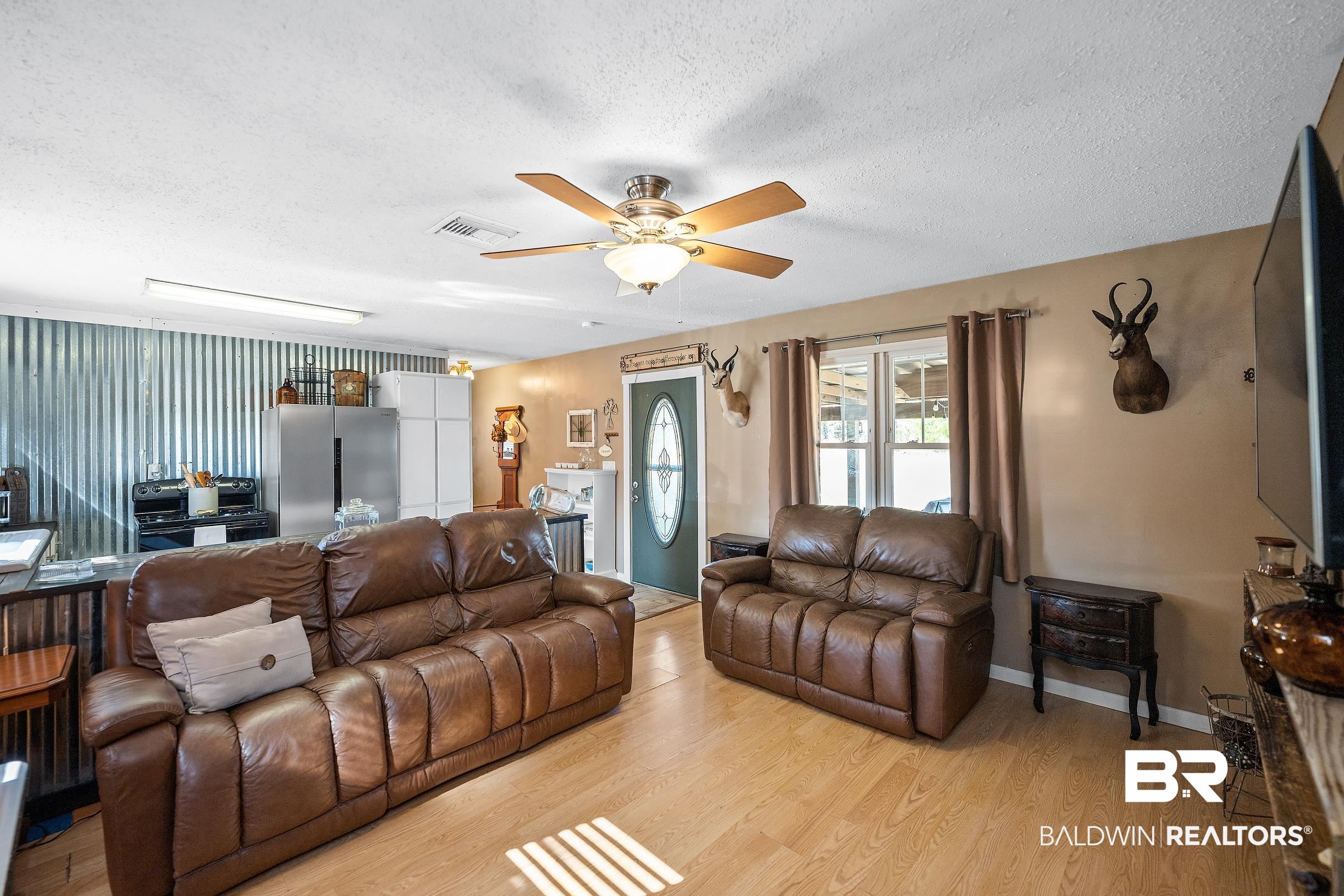 110 Sam Jones Road Atmore, AL 36502 - Photo 13 of 47 Living area featuring a textured ceiling, a ceiling fan, and light wood-type flooring