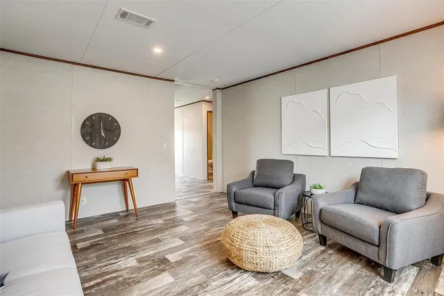 a living room with furniture a rug and a wall painting