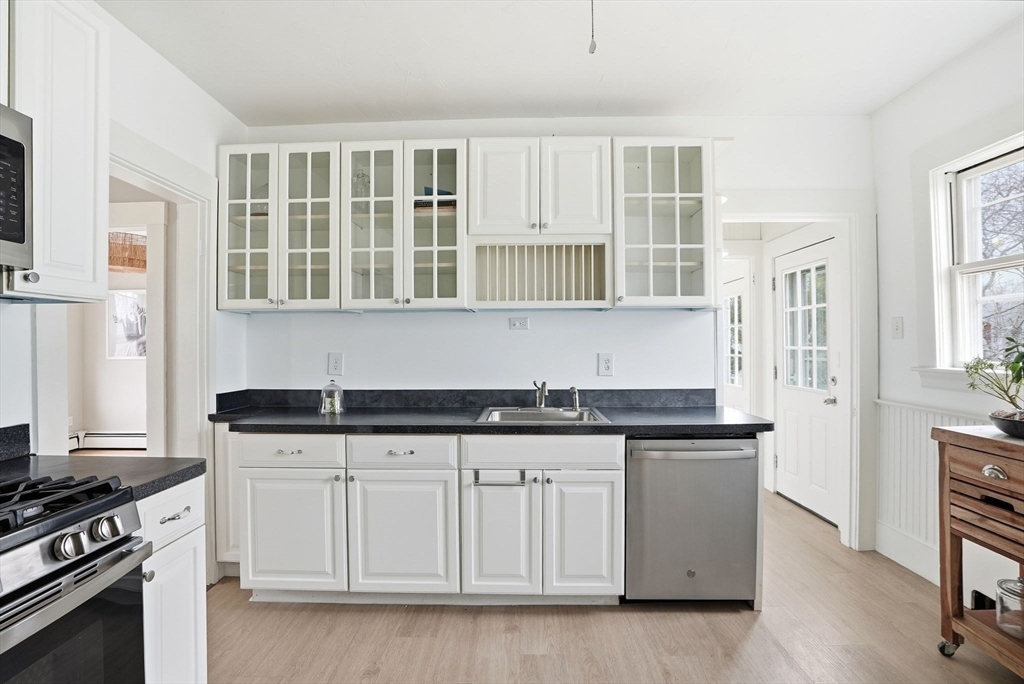48 Bates Street Hull, MA 02045 - Photo 11 of 42 a kitchen with granite countertop a stove a sink and dishwasher