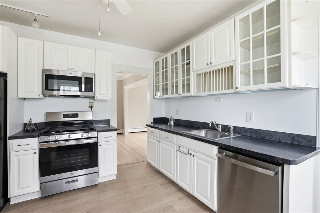 48 Bates Street Hull, MA 02045 - Photo 13 of 42 a kitchen with stainless steel appliances granite countertop a stove microwave and cabinets