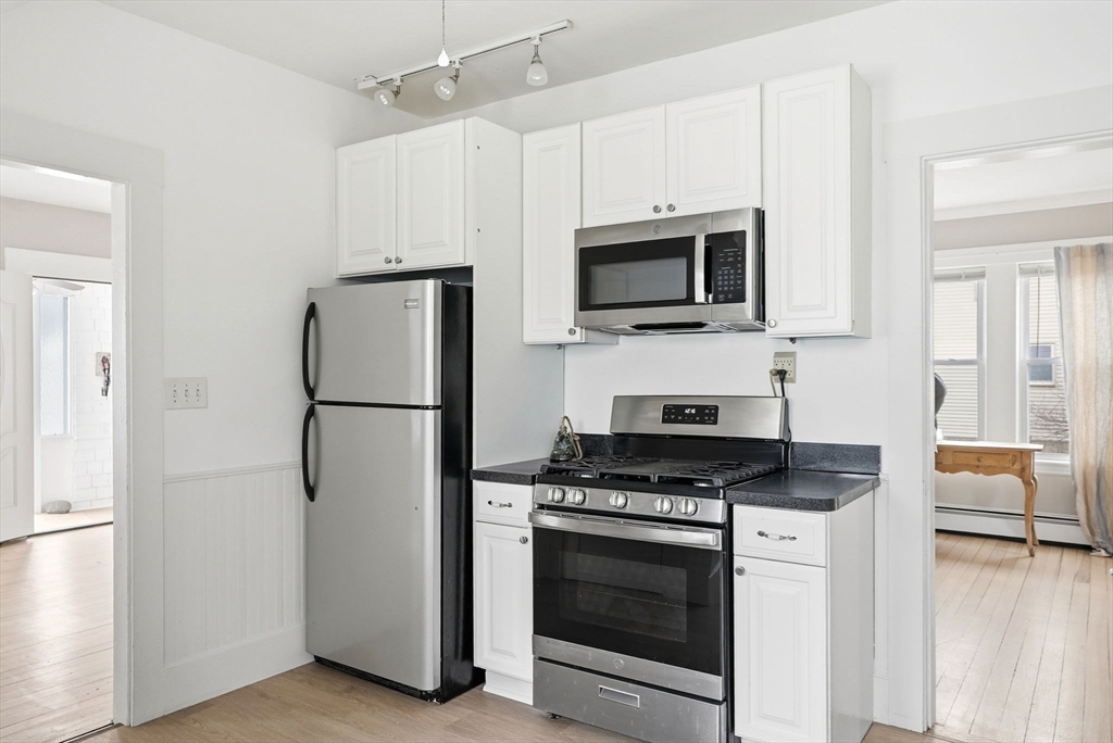48 Bates Street Hull, MA 02045 - Photo 10 of 42 a kitchen with cabinets stainless steel appliances and wooden floor