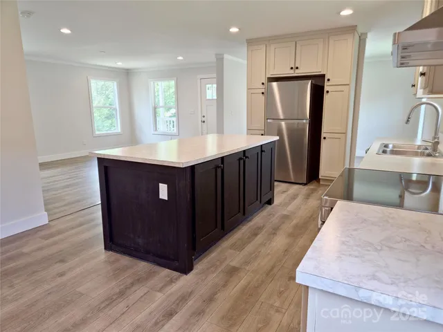 a kitchen with stainless steel appliances granite countertop a refrigerator a sink and a stove