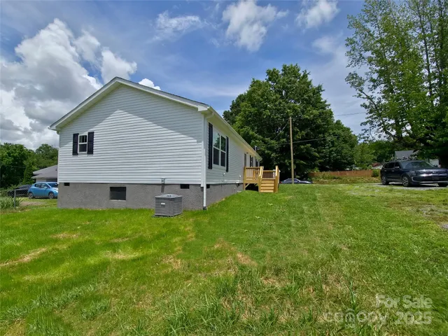 a view of a backyard with barn and large trees