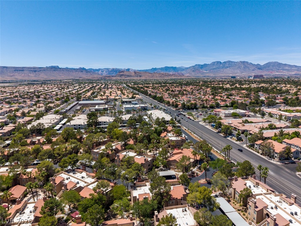9325 West Desert Inn Road, Unit 244 Las Vegas, NV 89117 - Photo 47 of 55 An aerial perspective reveals a sprawling community nestled against a distant mountain range.