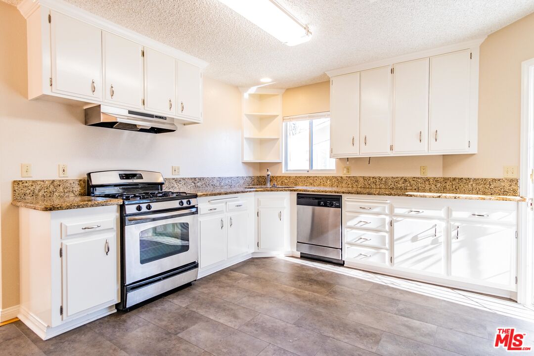 3865 Edenhurst Avenue Los Angeles, CA 90039 - Photo 16 of 22 a kitchen with granite countertop white cabinets and white appliances