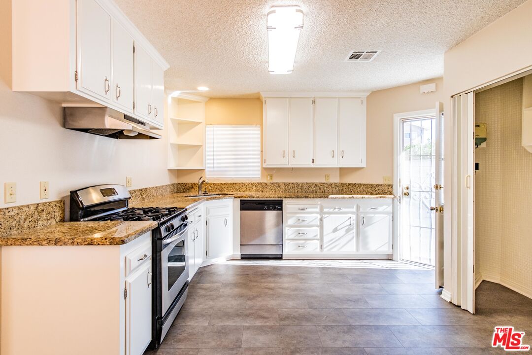 3865 Edenhurst Avenue Los Angeles, CA 90039 - Photo 6 of 22 a kitchen with stainless steel appliances granite countertop a stove and a refrigerator