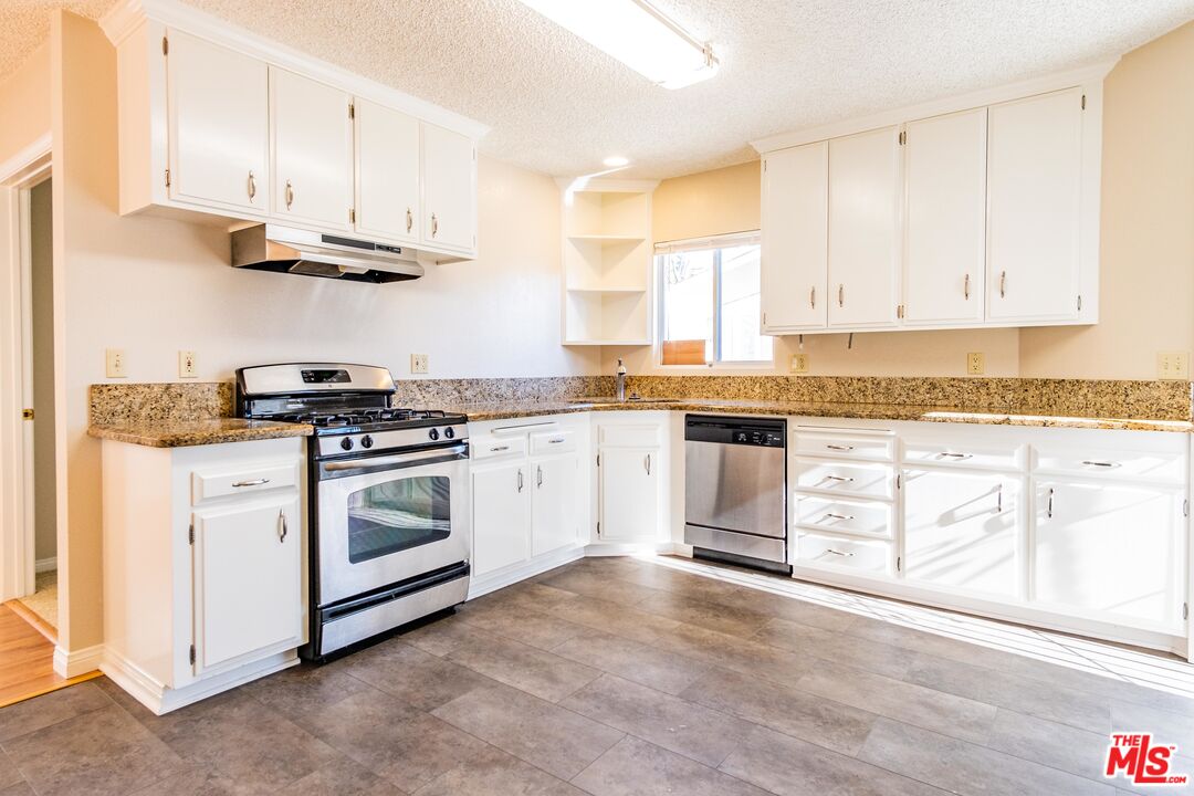 3865 Edenhurst Avenue Los Angeles, CA 90039 - Photo 7 of 22 a kitchen with granite countertop white cabinets and white appliances