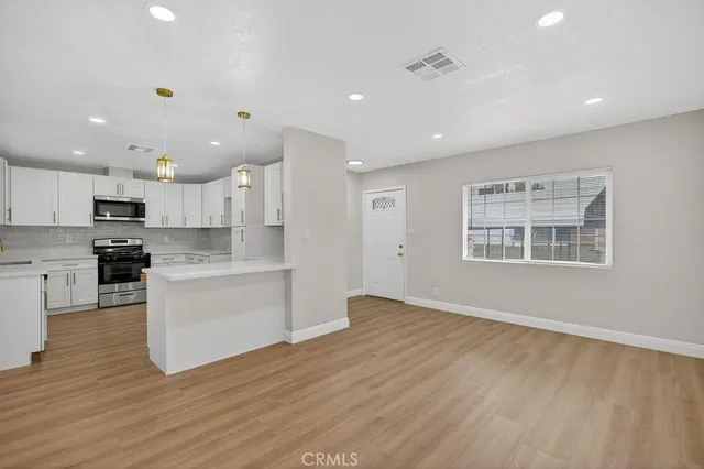 a kitchen with a refrigerator and white cabinets