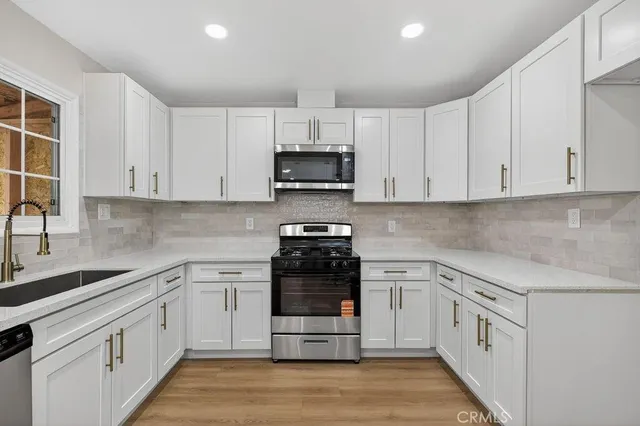 a kitchen with white cabinets and appliances