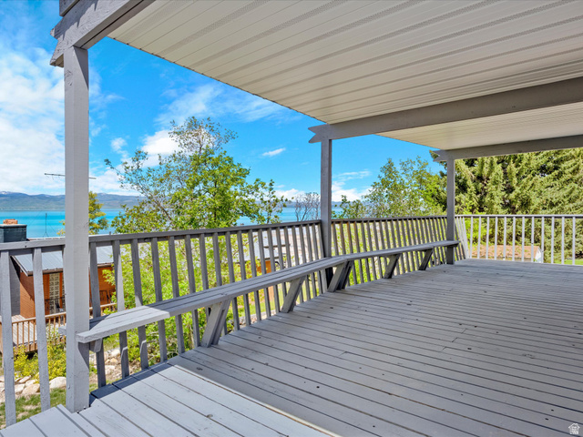 85 B Street, Unit 22 St. Charles, ID 83272 - Photo 10 of 35 Spacious covered deck featuring a built-in bench, wooden railing, and water scenery