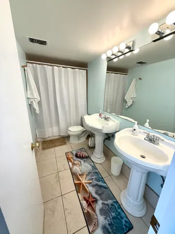 a bathroom with a sink mirror and toilet