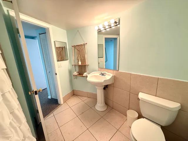 a bathroom with a sink toilet and a mirror