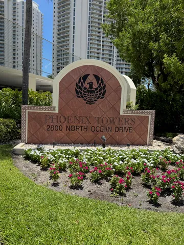 a sign that is sitting in front of flowers