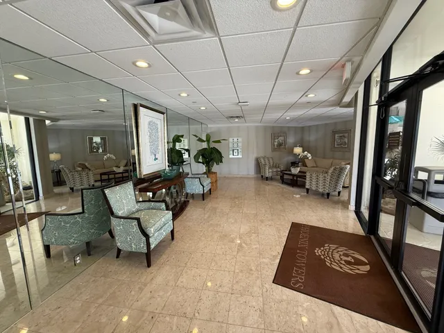 a lobby with furniture and a glass door shower