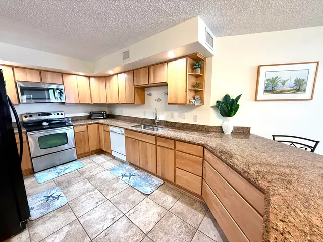 a kitchen with stainless steel appliances granite countertop a stove sink and cabinets