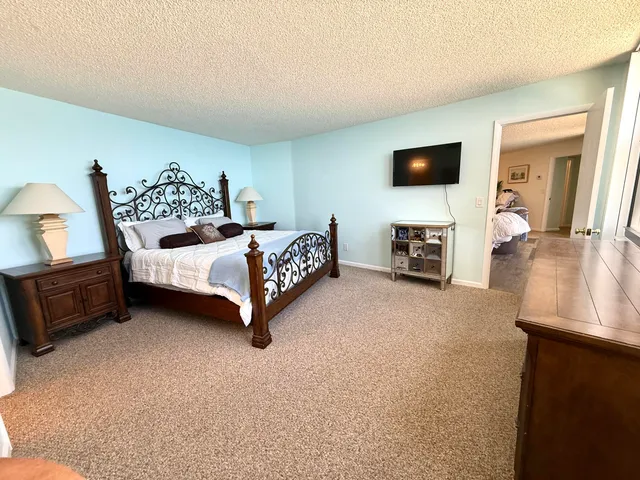a spacious bedroom with a bed and a flat screen television
