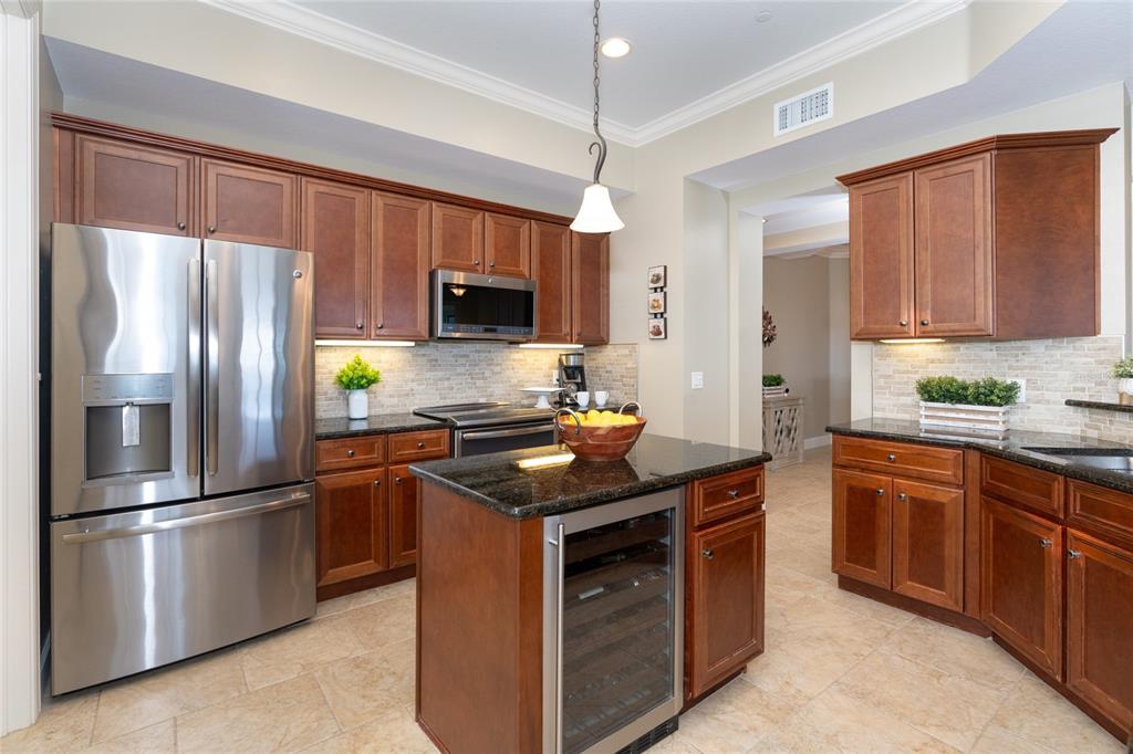 10501 Amberjack Way, Unit 402 Englewood, FL 34224 - Photo 11 of 45 a kitchen with stainless steel appliances granite countertop a stove a refrigerator and a sink