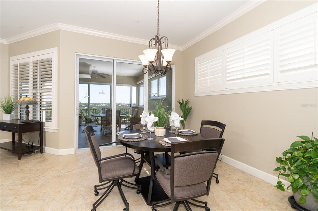 10501 Amberjack Way, Unit 402 Englewood, FL 34224 - Photo 16 of 45 a dining room with furniture a chandelier and wooden floor