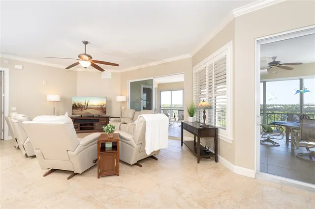 a view of a dining room with furniture a potted plant and a chandelier