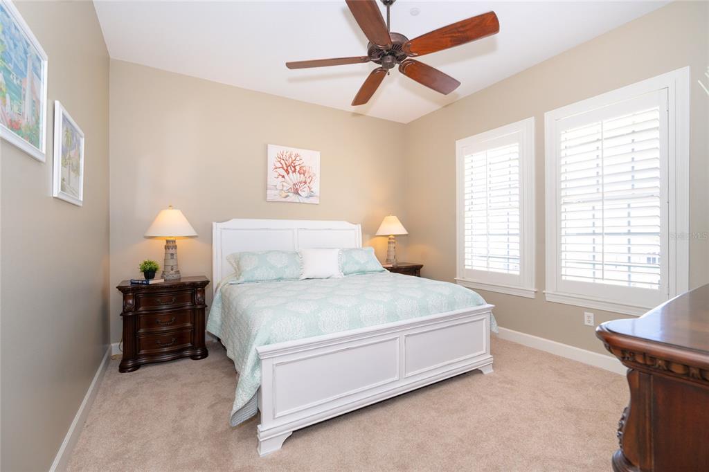 10501 Amberjack Way, Unit 402 Englewood, FL 34224 - Photo 33 of 45 a spacious bedroom with a bed and a chandelier