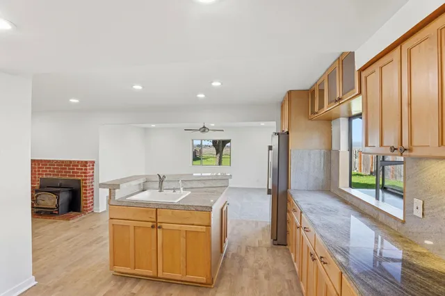 a kitchen with stainless steel appliances granite countertop a sink a stove and a refrigerator