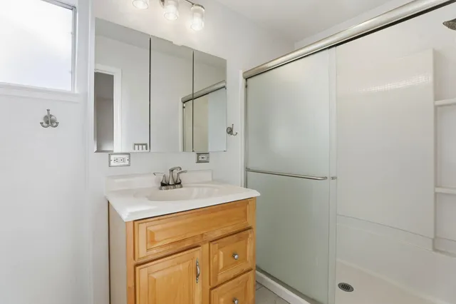 a bathroom with a sink mirror and shower