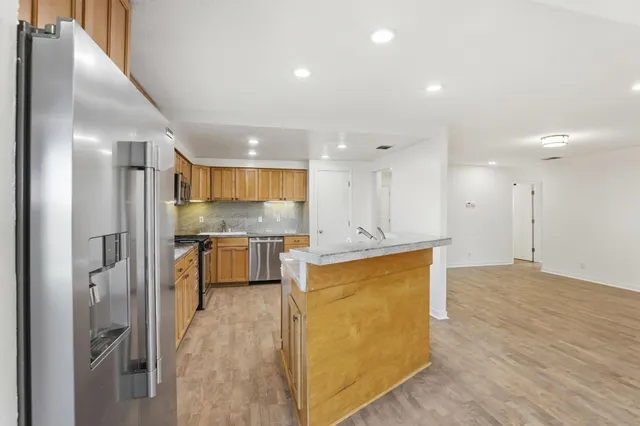 a view of kitchen with kitchen island and stainless steel appliances