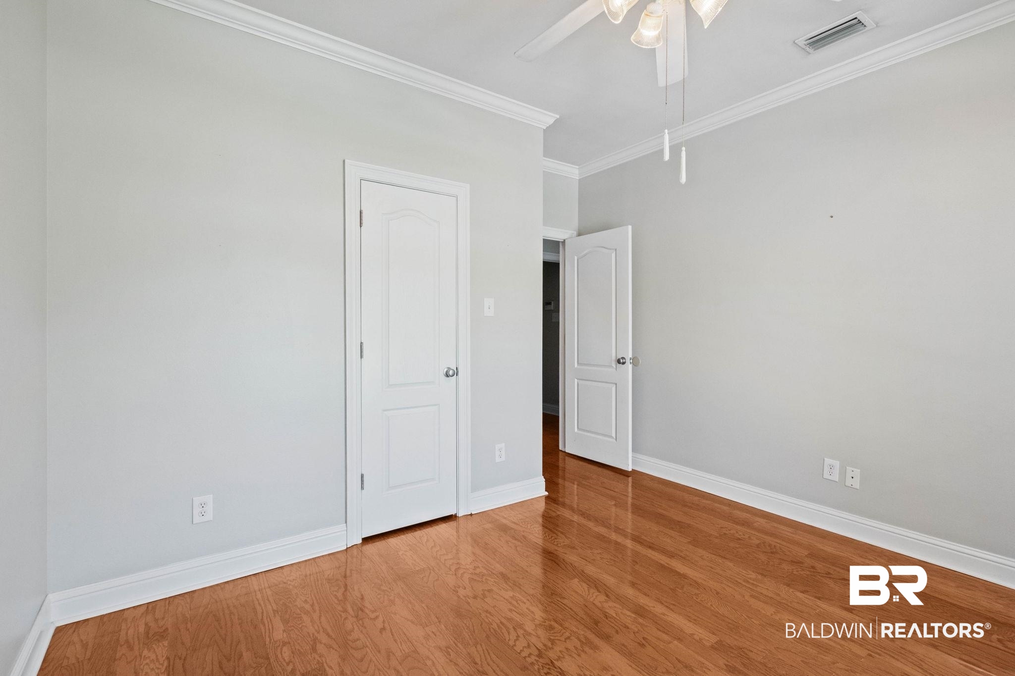 3176 Cedar Court Mobile, AL 36619 - Photo 20 of 33 Room featuring wood-finish flooring, light gray wall paint, white trim, and a ceiling fan with integrated lighting
