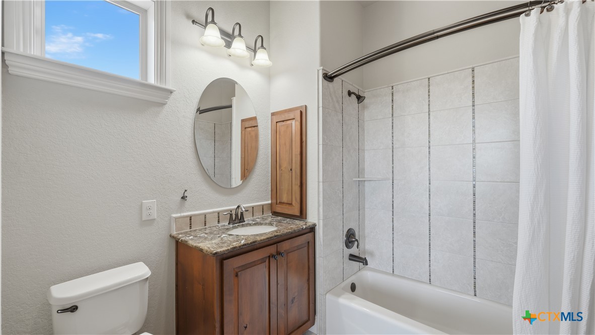 1035 Thunderbolt Rd Canyon Lake Canyon Lake, TX 78133 - Photo 30 of 48 a bathroom with a granite countertop sink toilet and a mirror
