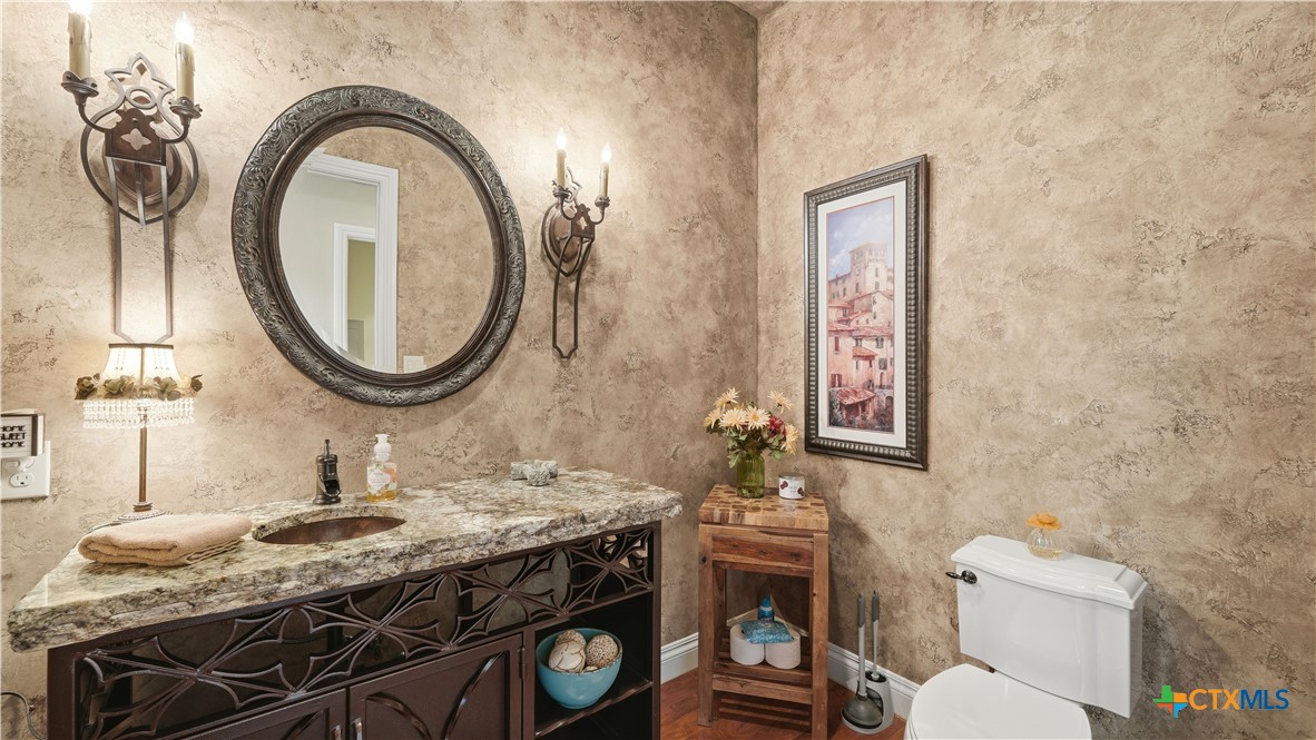 1035 Thunderbolt Rd Canyon Lake Canyon Lake, TX 78133 - Photo 41 of 48 a bathroom with a granite countertop toilet a sink and a mirror