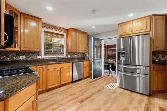 a kitchen with stainless steel appliances granite countertop a stove a sink and a microwave