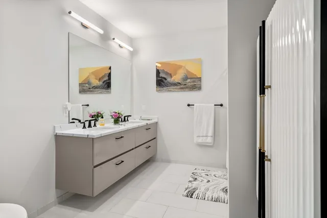 a bathroom with a sink mirror and vanity